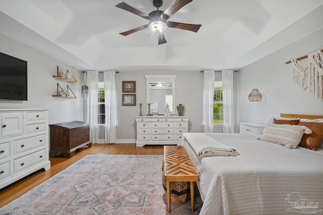 1333 Dubose Rd, Gulf Breeze, FL 32563 - bedroom featuring a raised ceiling, wood finished floors, ceiling fan, and baseboards