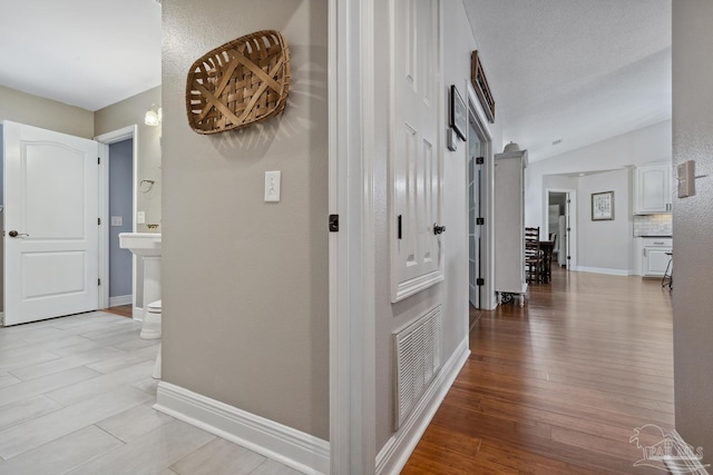 1333 Dubose Rd, Gulf Breeze, FL 32563 - hallway with light wood-style flooring, baseboards, and vaulted ceiling