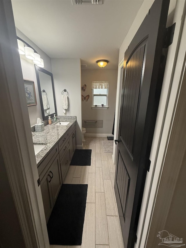5407 Maverick Ln, Gulf Breeze, FL 32563 - bathroom with double vanity, toilet, wood tiled floor, a shower, and a sink