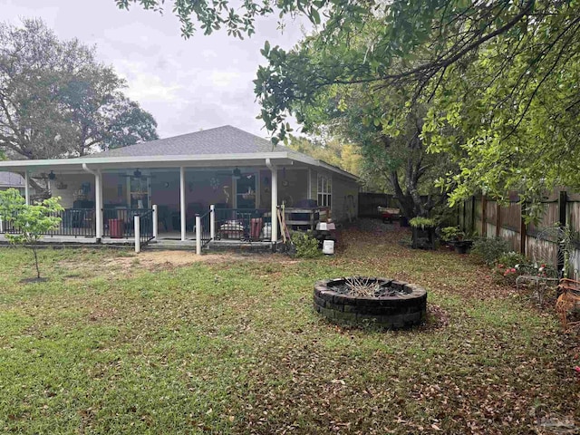 5407 Maverick Ln, Gulf Breeze, FL 32563 - rear view of property featuring a fire pit, a yard, a fenced backyard, a patio, and roof with shingles