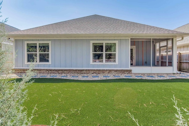 back of property featuring a sunroom and a yard