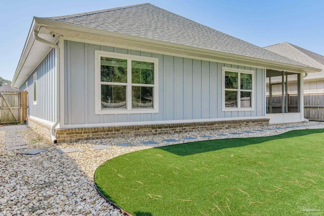 rear view of house with a sunroom and a lawn