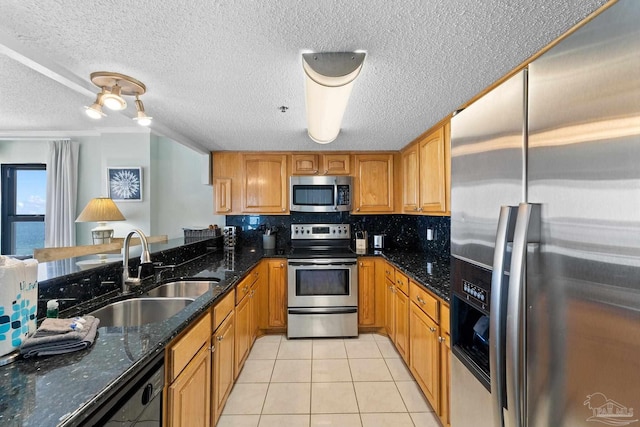 kitchen featuring dark stone countertops, sink, stainless steel appliances, a water view, and light tile patterned floors