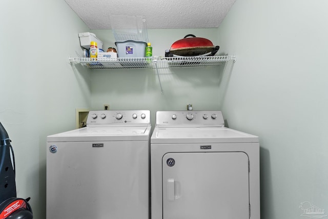 laundry room featuring washer and dryer and a textured ceiling