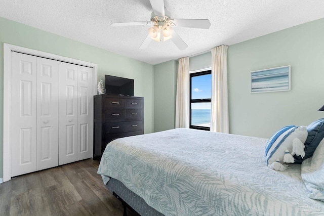 bedroom featuring ceiling fan, a textured ceiling, a closet, and dark hardwood / wood-style flooring