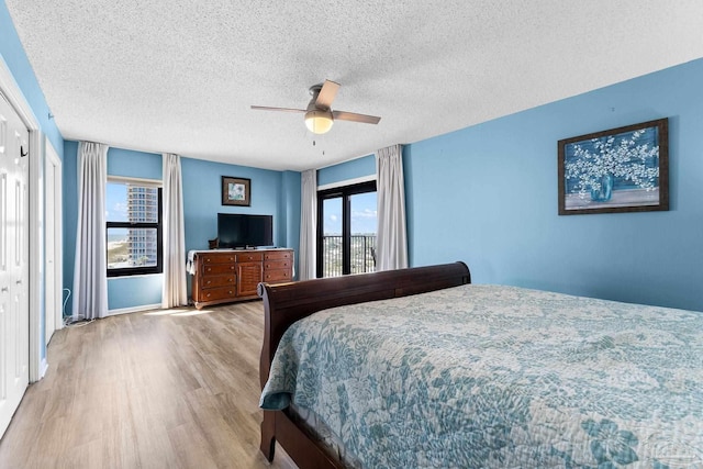 bedroom featuring a textured ceiling, ceiling fan, and light wood-type flooring