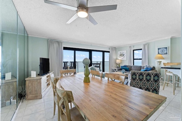 tiled dining space featuring ceiling fan and a textured ceiling