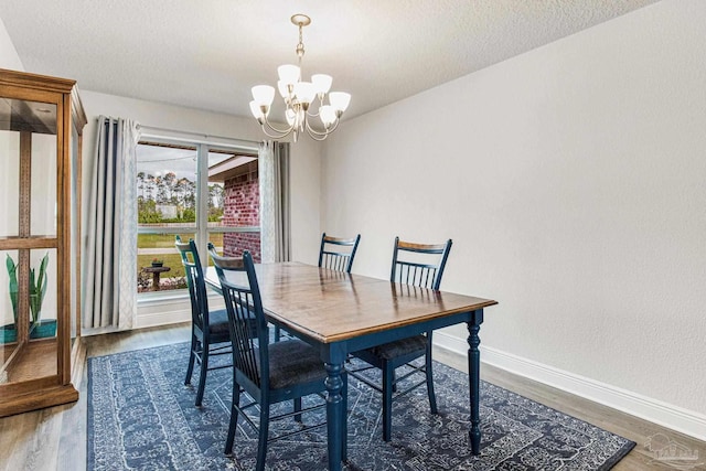 dining room featuring dark hardwood / wood-style flooring, a textured ceiling, and a chandelier