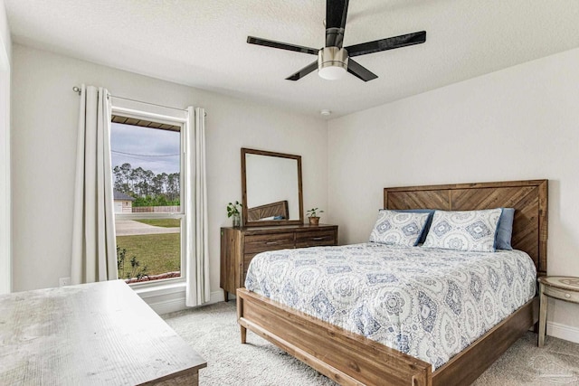 carpeted bedroom featuring a textured ceiling and ceiling fan