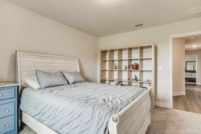 bedroom featuring carpet flooring and a textured ceiling