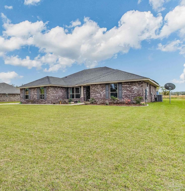 view of front of property with central AC and a front yard