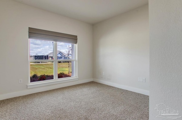 carpeted empty room with baseboards