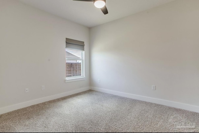 carpeted empty room with a ceiling fan and baseboards