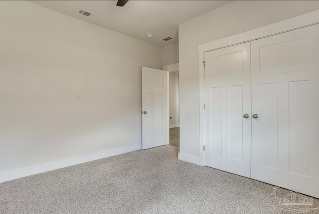unfurnished bedroom with a closet, a ceiling fan, baseboards, light colored carpet, and visible vents