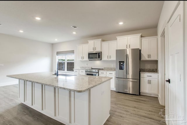 kitchen with white cabinets, a sink, appliances with stainless steel finishes, and visible vents