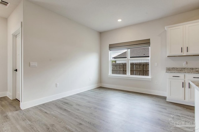 unfurnished dining area with baseboards, visible vents, and light wood-type flooring