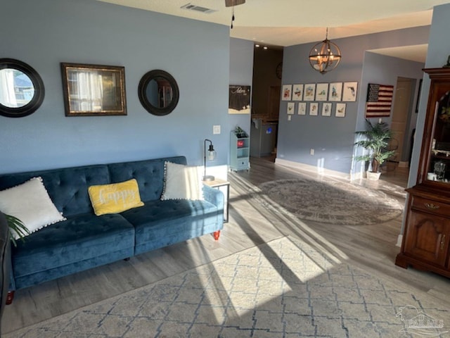 living room featuring hardwood / wood-style flooring and an inviting chandelier