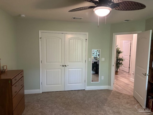 bedroom featuring ceiling fan, light colored carpet, and a closet