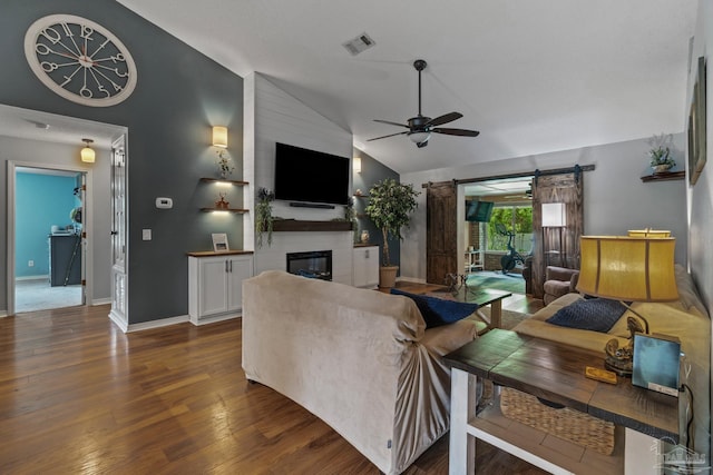 1265 Grand Ridge Cir, Gulf Breeze, FL 32563 - living area featuring a barn door, a ceiling fan, vaulted ceiling, dark wood-style floors, and a large fireplace