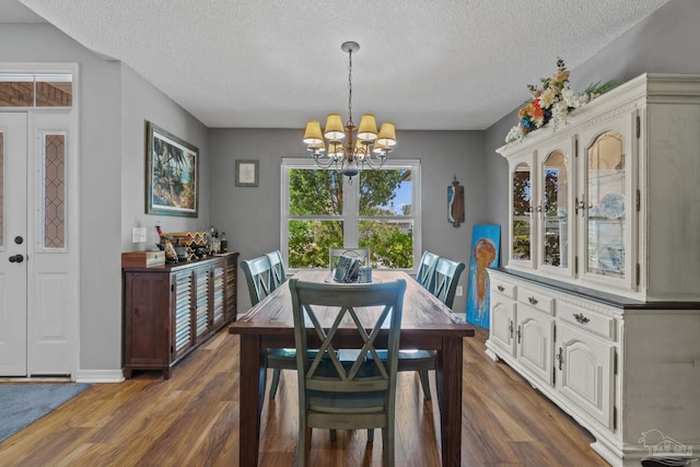 1265 Grand Ridge Cir, Gulf Breeze, FL 32563 - dining space with a textured ceiling, a chandelier, wood finished floors, and baseboards