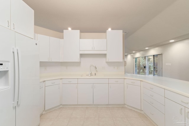 kitchen with white cabinets, white fridge with ice dispenser, and sink