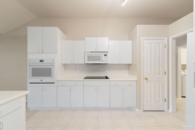 kitchen featuring white cabinets, washer / dryer, white appliances, and vaulted ceiling