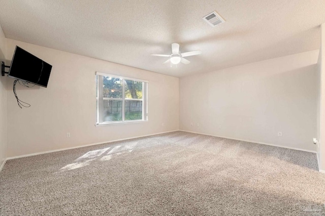 carpeted empty room featuring ceiling fan and a textured ceiling