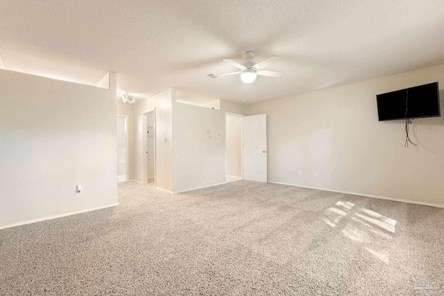 unfurnished room featuring ceiling fan, carpet floors, and a textured ceiling