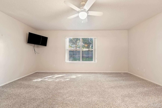 empty room with ceiling fan, carpet floors, and a textured ceiling