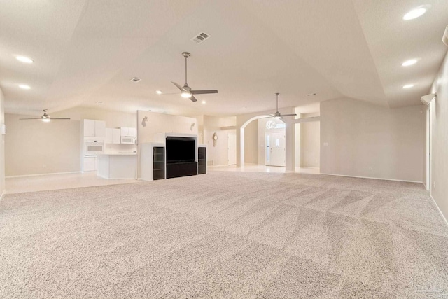 unfurnished living room featuring ceiling fan, carpet floors, and vaulted ceiling