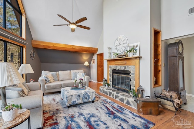 living room with high vaulted ceiling, wood finished floors, ceiling fan, and a premium fireplace