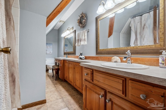 bathroom with double vanity, toilet, a sink, and tile patterned floors