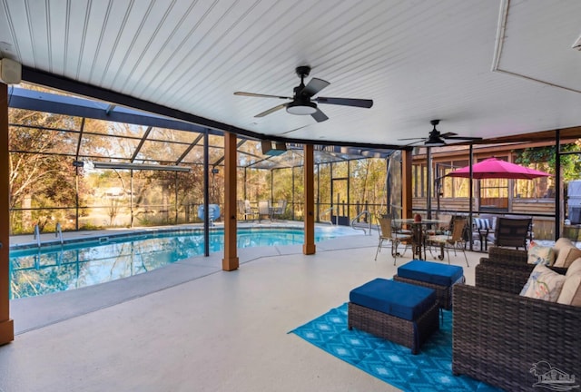 outdoor pool with glass enclosure, an outdoor hangout area, ceiling fan, and a patio area