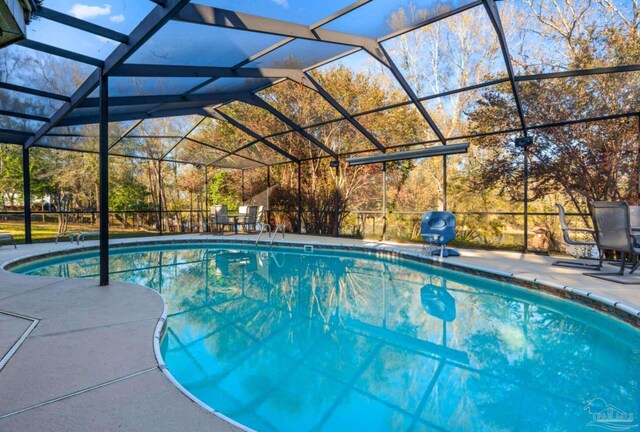 pool with glass enclosure and a patio area