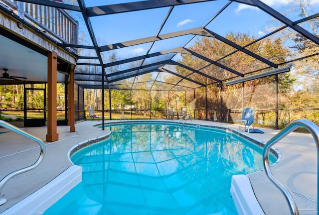 outdoor pool featuring glass enclosure and a patio area
