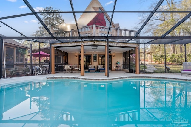outdoor pool with glass enclosure, an outdoor living space, ceiling fan, and a patio