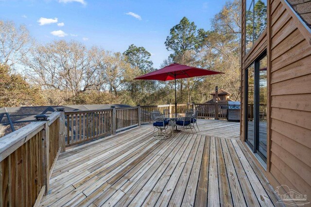 deck featuring outdoor dining area and area for grilling