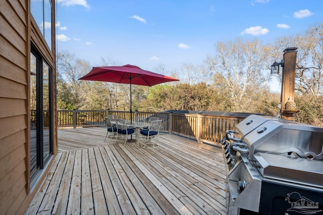 wooden deck with outdoor dining area and area for grilling