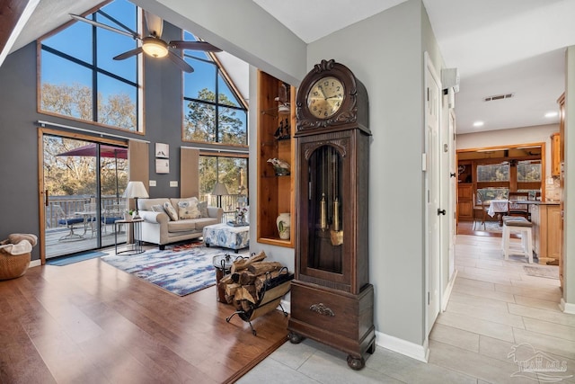 sitting room with baseboards, visible vents, ceiling fan, and light wood-style flooring