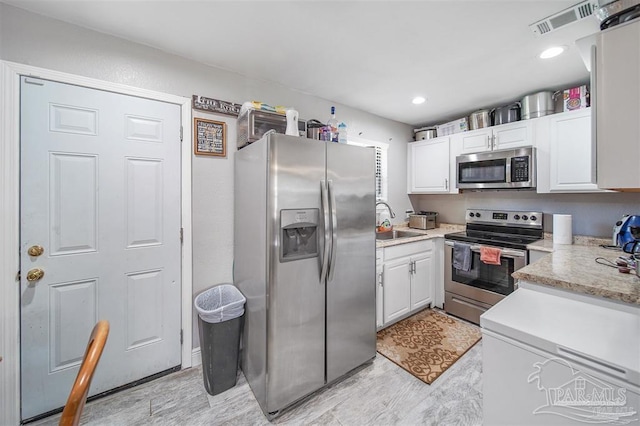 kitchen featuring white cabinetry, sink, and appliances with stainless steel finishes