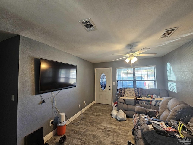 living room featuring hardwood / wood-style floors, a textured ceiling, and ceiling fan