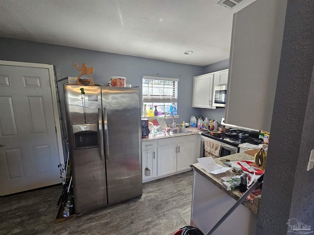 kitchen featuring white cabinetry, stainless steel appliances, sink, and wood-type flooring