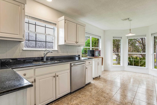 kitchen with hanging light fixtures, dishwasher, white cabinetry, and sink