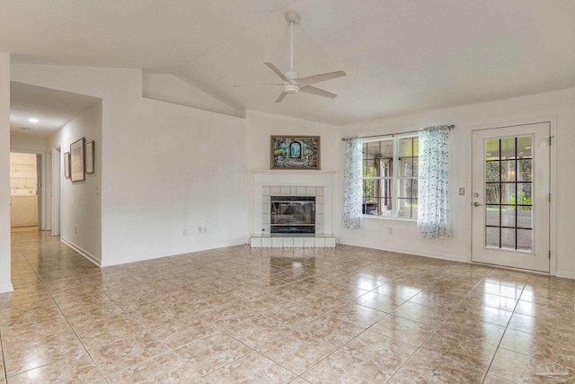 unfurnished living room featuring ceiling fan, light tile patterned floors, a fireplace, and vaulted ceiling