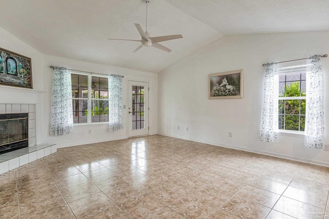 unfurnished living room with a tiled fireplace, a textured ceiling, ceiling fan, vaulted ceiling, and light tile patterned flooring