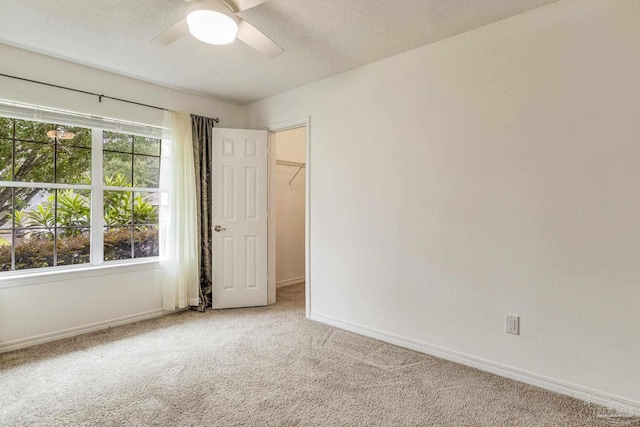 carpeted spare room with a textured ceiling and ceiling fan