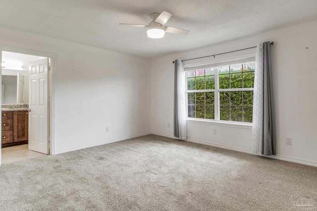 unfurnished room with light colored carpet, ceiling fan, and a textured ceiling