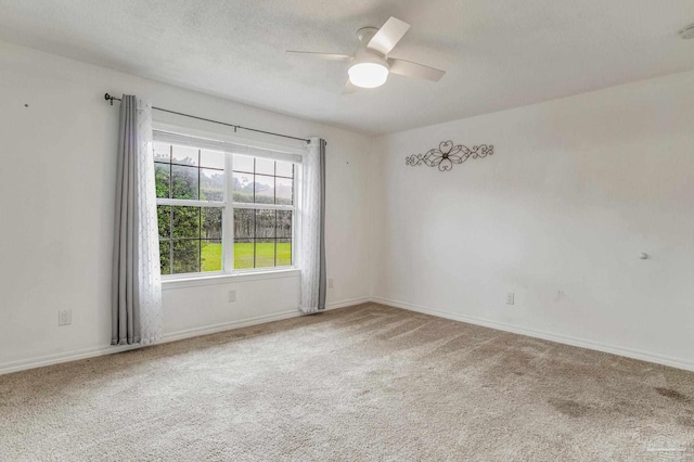 carpeted empty room with a textured ceiling and ceiling fan