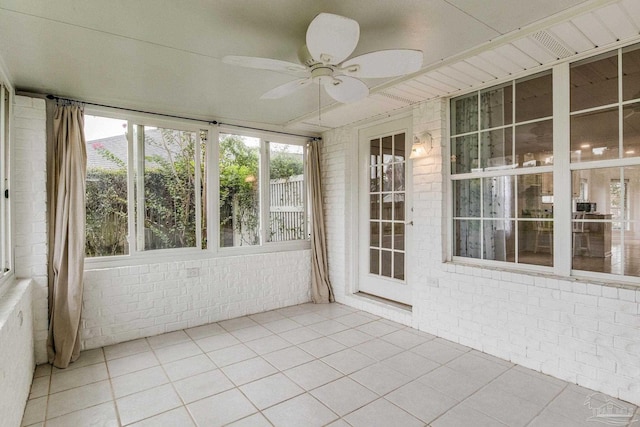 unfurnished sunroom with ceiling fan and a healthy amount of sunlight