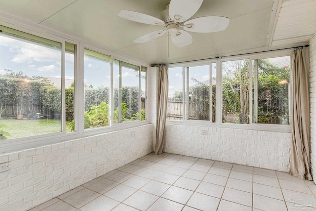 unfurnished sunroom featuring a wealth of natural light and ceiling fan